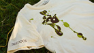 Shirt on grass showing BEEDOCS logo on sleeve and Natural Selection illustration on the front.