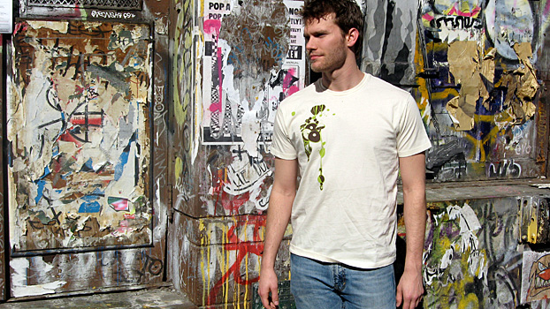 Shirt on grass showing BEEDOCS logo on sleeve and Natural Selection illustration on the front.